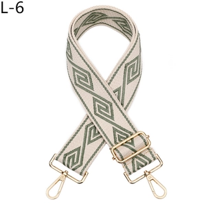 Détail de la bandoulière tissée à motifs verts avec mousquetons dorés réglables