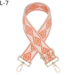 Détail de la bandoulière réglable à motif losange géométrique beige orange et boucles dorées