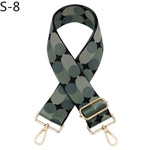 Detail of adjustable bag strap with blue dot jacquard pattern and golden metal buckles