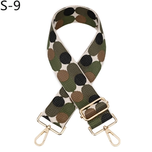 Detailed close-up of wide woven bag strap with green and brown camo dots and gold hooks