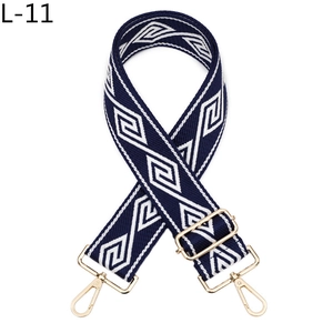 Détail d'une bandoulière ajustable à motifs losanges bleu marine avec mousquetons dorés