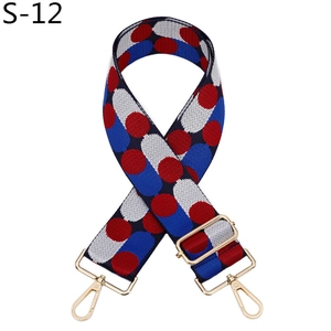 Detail of red and blue polka dot fabric bag strap with golden swivel hooks