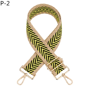 Détail de la bandoulière tissée réglable avec motif en V jaune et boucles dorées