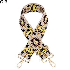 Close-up of ethnic geometric pattern strap with golden metal swivel hooks and buckle