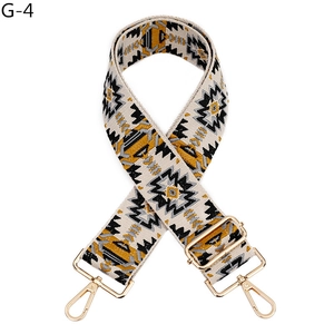 Detailed view of ethnic embroidery bag strap with gold metal hooks and adjustable buckle