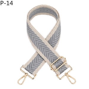 Détail de la bandoulière tressée grise avec chevrons et crochets métalliques dorés