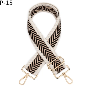 Détail de la bandoulière ajustable à motif chevron noir et accessoires en métal doré chic