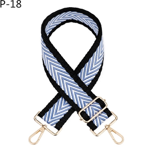 Détail de la bandoulière tissée à motif flèche avec mousquetons et boucles dorés