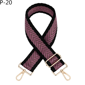 Détail de la bandoulière tissée violette et marron avec des mousquetons en métal doré
