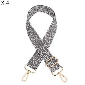 Macro shot of grey leopard pattern bag strap with polished light gold metal hardware