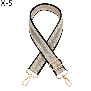 Detail of woven leopard stripe bag strap with golden metallic thread and metal buckles