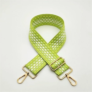Adjustable wide woven shoulder strap with green and white geometric pattern and gold hardware