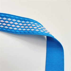 Detailed macro view of the blue jacquard woven strap with pink and white diamond patterns