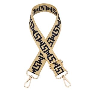 Detail of adjustable beige bag strap with black geometric pattern and gold swivel hooks