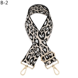 Detail of adjustable leopard print bag strap with golden metal lobster clasps and buckles