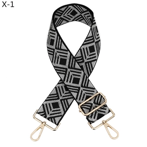 Détail de la bandoulière tissée à losanges noirs et blancs avec boucle dorée