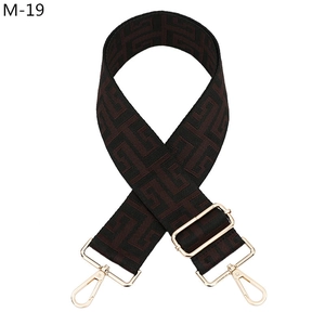 Detail of adjustable woven guitar strap with geometric pattern and gold metal hooks