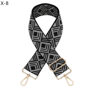 Gros plan sur bandoulière large à motifs losanges avec mousquetons métalliques dorés