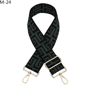 Detail view of jacquard woven geometric wide strap with golden metal lobster clasps