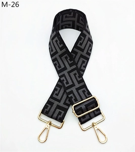 Detailed view of maze pattern woven shoulder strap with gold-tone metal buckles
