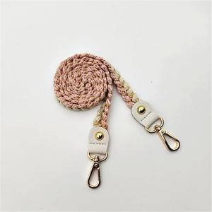 Detail of pink and beige braided cotton strap with gold metallic threads and lobster clasps