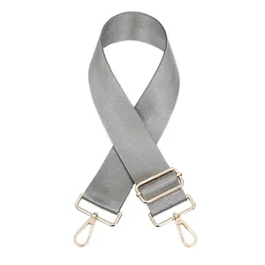 Gros plan sur la bandoulière en nylon gris avec fermoirs mousquetons en métal doré
