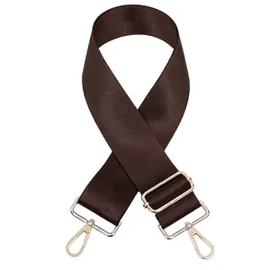 Détail de la bandoulière réglable en nylon marron foncé avec mousquetons dorés