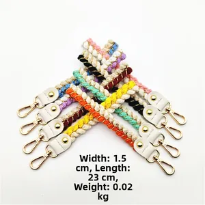 Close-up of colorful braided nylon wrist straps with gold lobster clasps and leather tabs