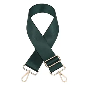 Détail de la bandoulière en nylon vert foncé avec boucle et fermoirs en métal doré