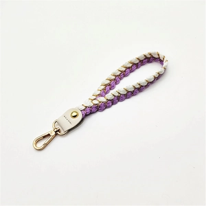 Close-up of woven wrist strap with purple and gold rope textures and metallic gold clasp