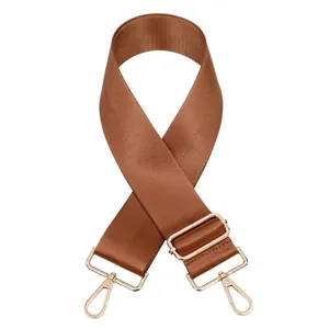 Détail de la bandoulière réglable en nylon marron avec crochets en métal doré poli
