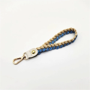 Detail of blue and beige braided rope strap with golden lobster clasp for bags and keys
