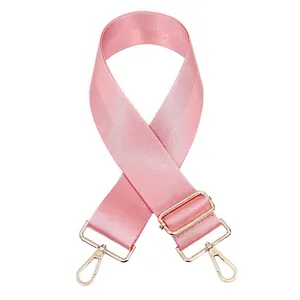 Détail de la bandoulière réglable en nylon rose avec mousquetons en métal doré
