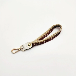 Close-up of woven cotton rope strap with gold accents and metallic lobster clasp