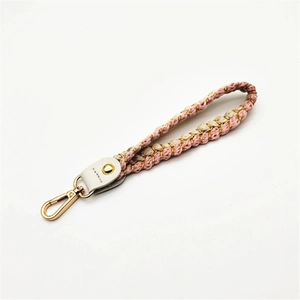 Detail of pink and cream braided cotton wrist strap with gold metallic threads and lobster clasp