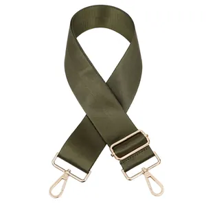 Détail d'une bandoulière en nylon vert olive réglable avec des boucles en métal doré poli