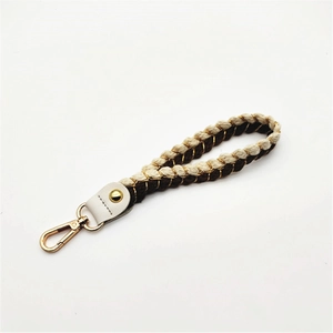 Detail of two-tone braided hand strap with gold-tone lobster clasp for handbags