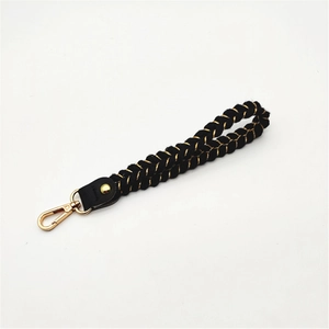Detailed shot of black and gold woven wrist strap with lobster clasp and leather connector