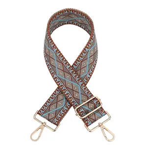 Close-up of geometric diamond pattern woven shoulder strap with gold metal hooks