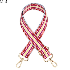 Détail de la bandoulière rayée réglable avec mousquetons dorés et boucles métalliques