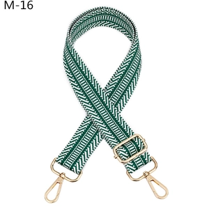 Détail de la bandoulière tissée réglable à chevrons vert et blanc avec crochets dorés