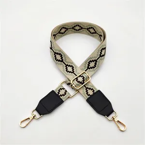 Detailed macro of ethnic woven strap with green patterns and golden metal snap hooks