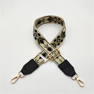Close-up of geometric ethnic bag strap with gold metal buckles and black leather ends