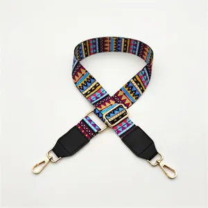 Close-up of ethnic style geometric bag strap with black leather ends and gold hooks