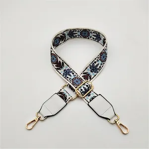 Close-up of bohemian geometric patterns and golden metal hardware on a white SPU strap