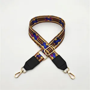 Close-up of geometric ethnic pattern woven strap with black leather ends and gold buckle
