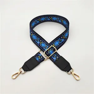 Close-up of ethnic style blue and yellow floral wide shoulder strap with gold metal hooks