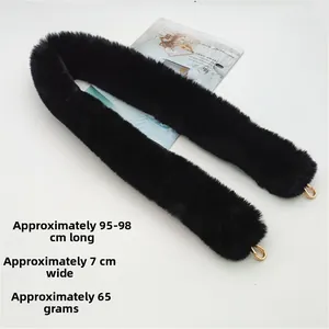 Detail view of a black faux fur bag strap featuring gold metal lobster clasps