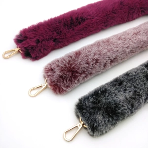 Detailed macro view of soft faux fur handbag straps in purple, pink and grey with gold hooks