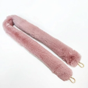 Close-up of pink faux fur shoulder strap with elegant gold metal U-shaped hooks